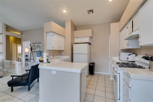 2595 Fort Lauderdale Dr, Las Vegas, NV 89156 - kitchen featuring white appliances, under cabinet range hood, tile counters, a sink, and a peninsula