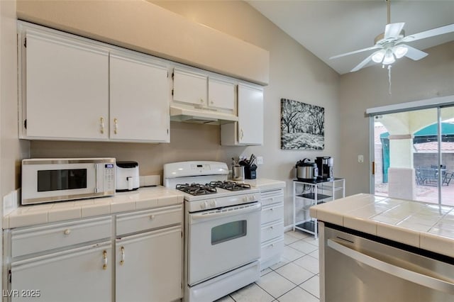 2595 Fort Lauderdale Dr, Las Vegas, NV 89156 - kitchen with white appliances, under cabinet range hood, lofted ceiling, tile countertops, and white cabinets