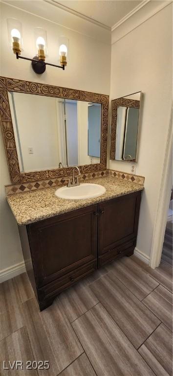 4308 Apex Dr, Las Vegas, NV 89147 - bathroom featuring crown molding, vanity, baseboards, and wood finished floors