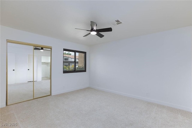 unfurnished bedroom featuring visible vents, carpet flooring, baseboards, and a closet