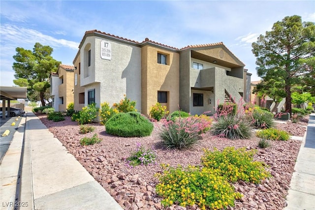 view of side of home with stucco siding and a tile roof