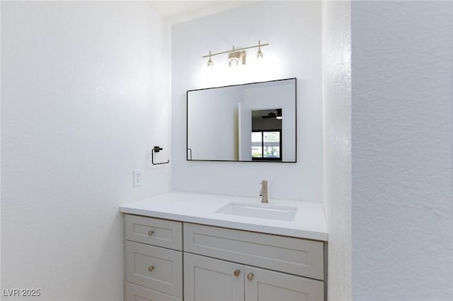 bathroom with vanity and a textured wall