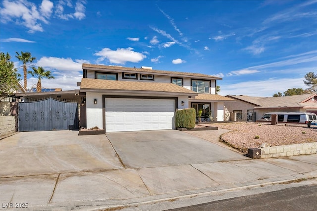 traditional home featuring a garage, fence, concrete driveway, a shingled roof, and stucco siding