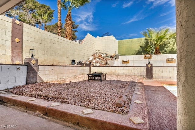 view of yard with a fenced backyard and a fire pit