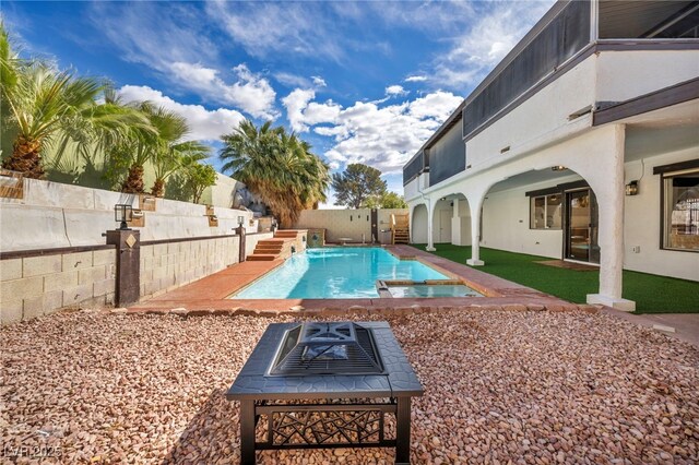 view of swimming pool with a patio area, a fenced backyard, a fire pit, and a pool with connected hot tub
