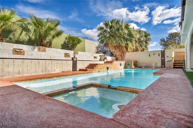 view of swimming pool featuring a fenced backyard and a pool with connected hot tub