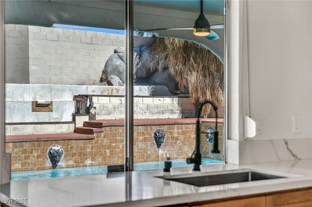 room details featuring a sink, decorative backsplash, and ceiling fan
