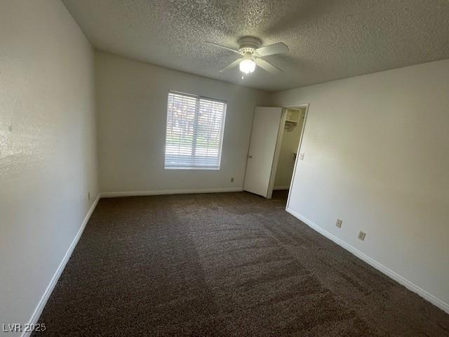 carpeted empty room with a ceiling fan, a textured ceiling, and baseboards