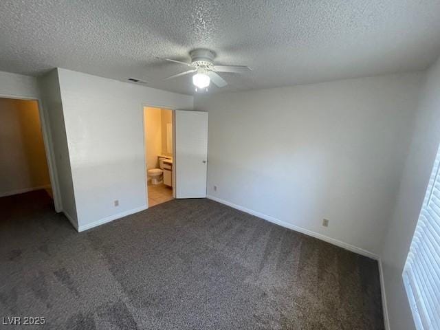 unfurnished bedroom featuring carpet floors, a textured ceiling, and baseboards