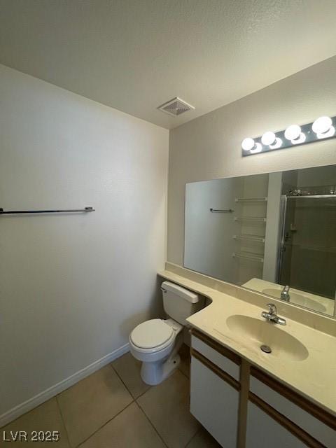 bathroom with tile patterned flooring, vanity, toilet, baseboards, and a shower stall
