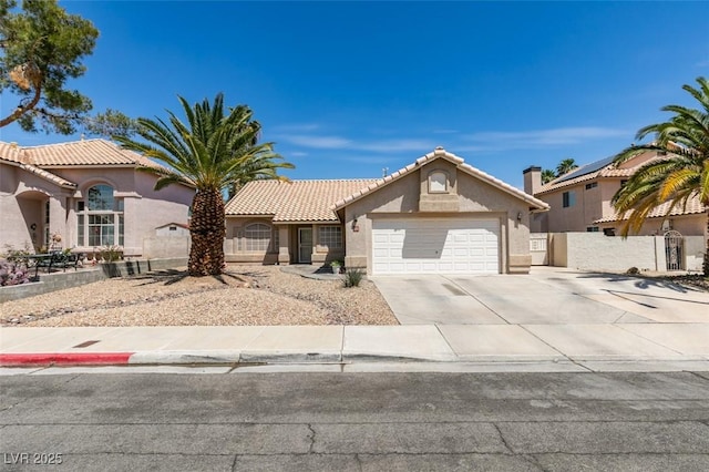 view of front facade with a garage, fence, stucco siding, driveway, and a tile roof