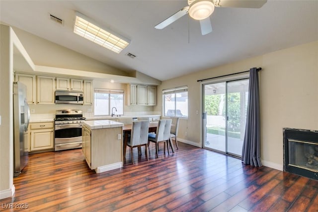 kitchen featuring tile countertops, appliances with stainless steel finishes, a wealth of natural light, and visible vents
