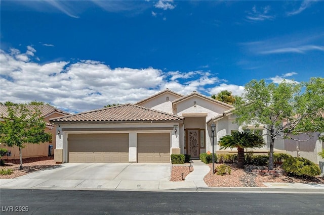 mediterranean / spanish-style house featuring concrete driveway, a tiled roof, an attached garage, and stucco siding