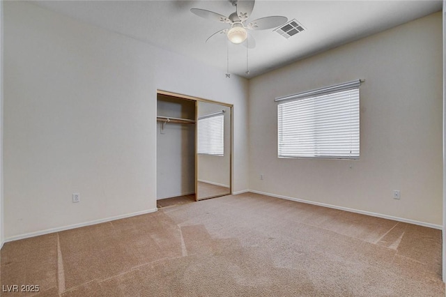 unfurnished bedroom with a ceiling fan, visible vents, carpet floors, baseboards, and a closet