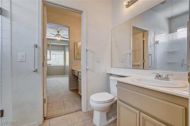 bathroom featuring ceiling fan, tile patterned flooring, vanity, toilet, and a shower with door
