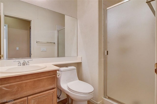 full bathroom with vanity, a stall shower, and toilet