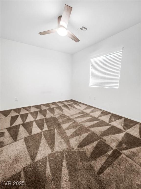 carpeted spare room with ceiling fan and visible vents
