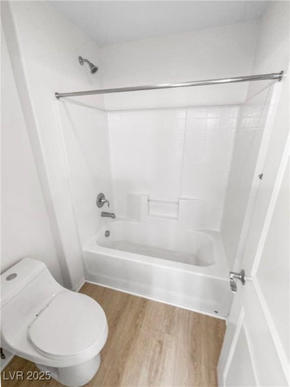 bathroom featuring shower / bath combination, wood finished floors, and toilet