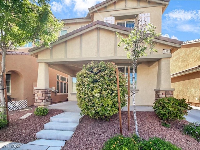 property entrance featuring stucco siding and stone siding