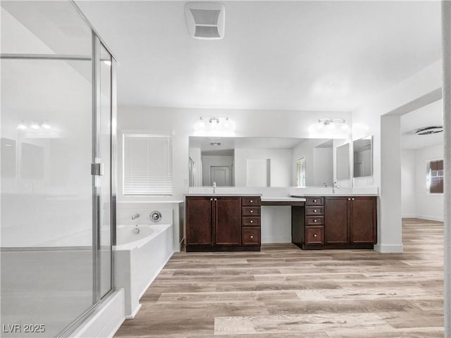 full bathroom with vanity, wood finished floors, a bath, and a stall shower