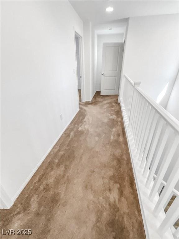 hall with carpet floors, baseboards, and recessed lighting