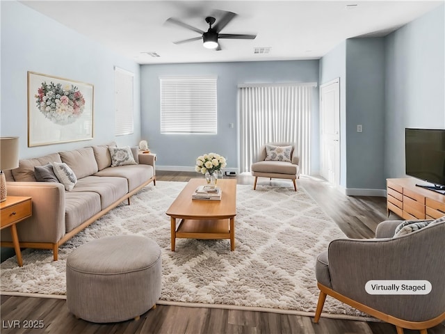 living area with baseboards, ceiling fan, visible vents, and wood finished floors