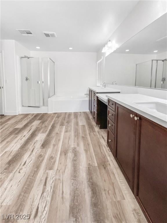 full bathroom featuring visible vents, wood finished floors, vanity, and a shower stall