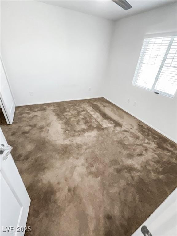 carpeted empty room with baseboards and ceiling fan