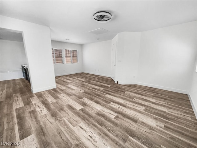 unfurnished room with baseboards and wood finished floors