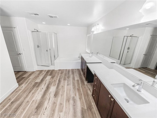 bathroom featuring a sink, a stall shower, and visible vents