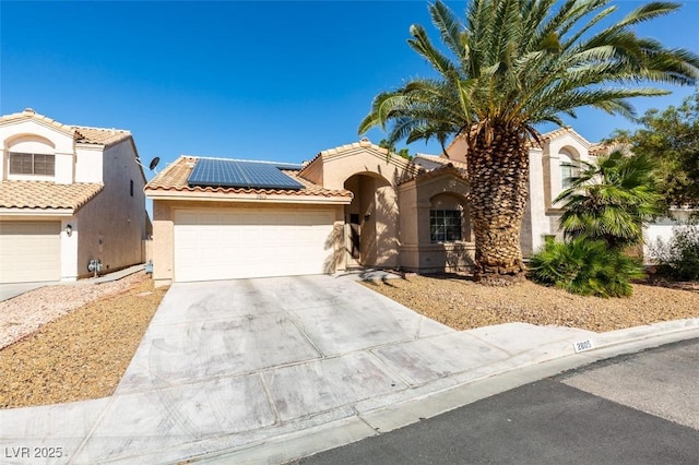 2805 Rungsted St, Las Vegas, NV 89142 - mediterranean / spanish-style house with an attached garage, stucco siding, concrete driveway, solar panels, and a tiled roof