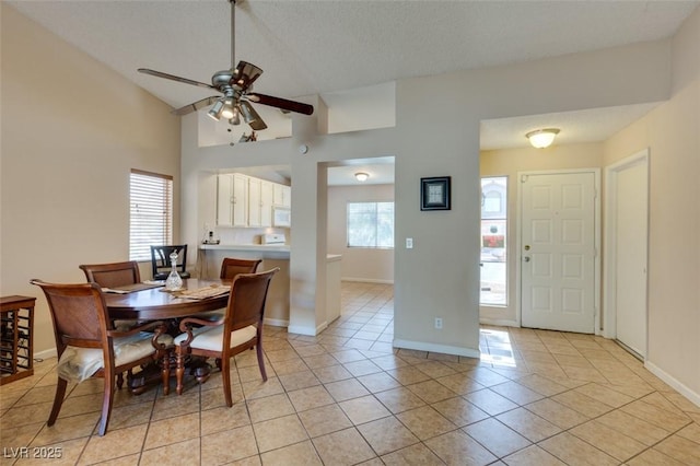 2805 Rungsted St, Las Vegas, NV 89142 - dining area with baseboards, a textured ceiling, a ceiling fan, light tile patterned floors, and vaulted ceiling