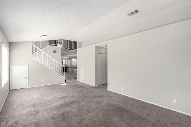6428 Yarmouth Dr, Las Vegas, NV 89108 - unfurnished living room with carpet floors, a textured ceiling, baseboards, visible vents, and stairway