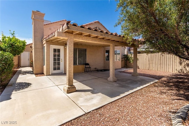 6428 Yarmouth Dr, Las Vegas, NV 89108 - back of house featuring fence, stucco siding, a chimney, a patio area, and a tiled roof