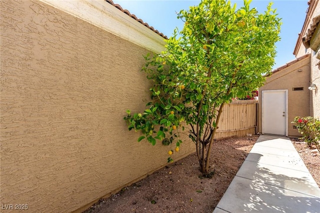 6428 Yarmouth Dr, Las Vegas, NV 89108 - view of side of property with a tiled roof, fence, and stucco siding