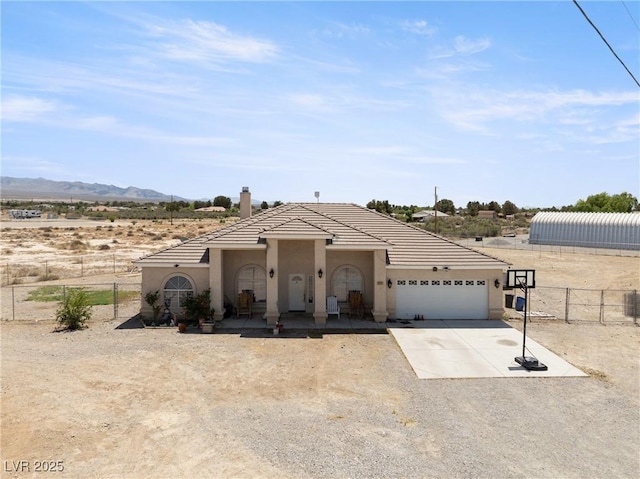 single story home with an attached garage, stucco siding, fence, and driveway