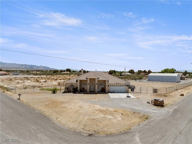 ranch-style home featuring fence, a mountain view, and dirt driveway