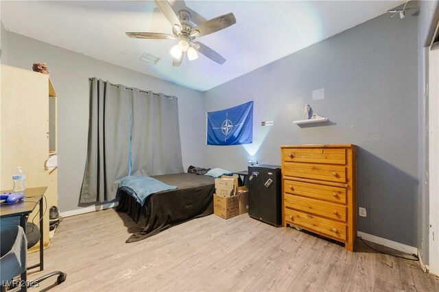 bedroom with a ceiling fan, baseboards, and wood finished floors