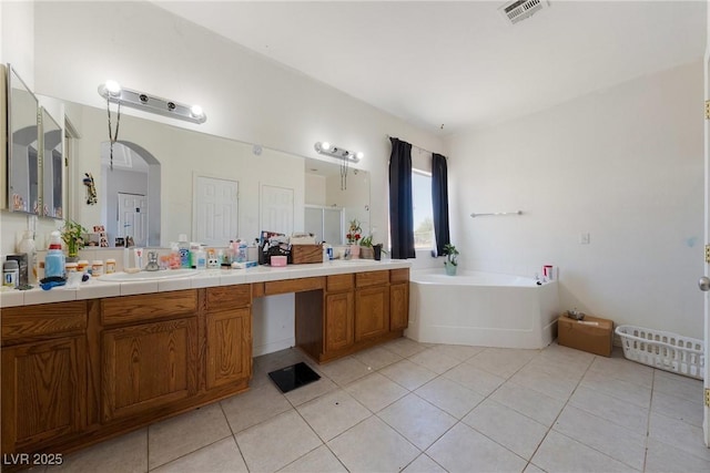 bathroom featuring tile patterned floors, vanity, and a garden tub