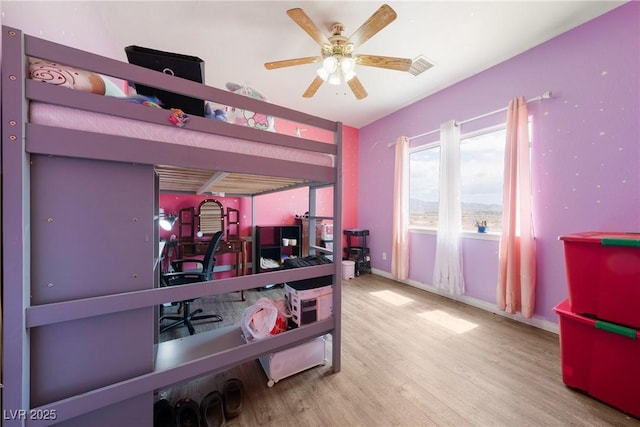 bedroom featuring a ceiling fan, baseboards, visible vents, and wood finished floors