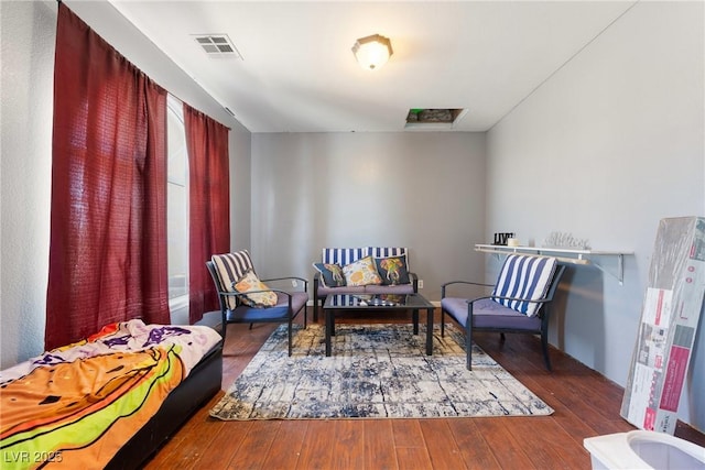 living area featuring hardwood / wood-style floors and visible vents