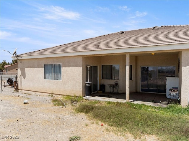 back of house with a patio, stucco siding, and a tiled roof
