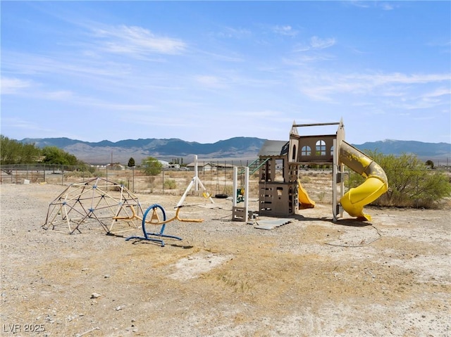 communal playground featuring fence and a mountain view