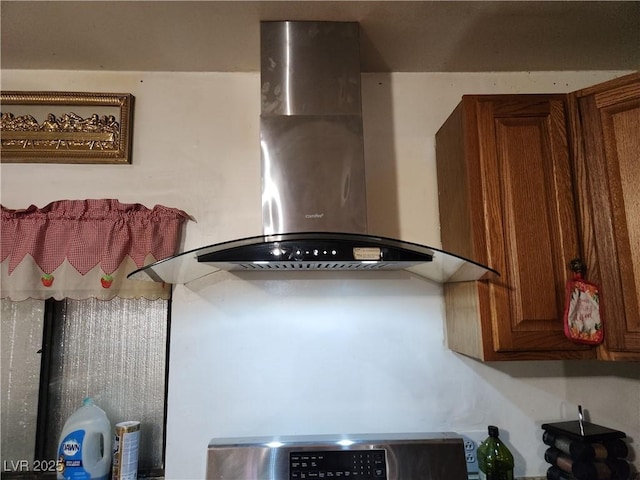 details with brown cabinetry and wall chimney exhaust hood