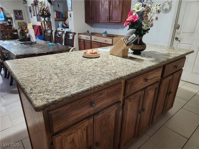 kitchen featuring light tile patterned floors and light stone countertops