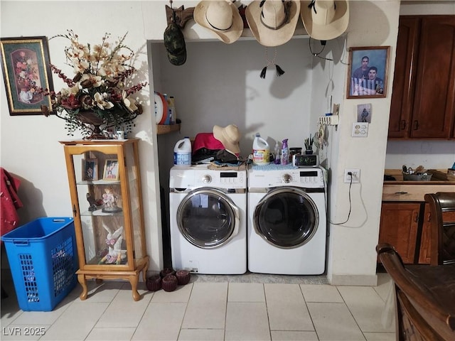 clothes washing area with light tile patterned floors, laundry area, and washer and clothes dryer