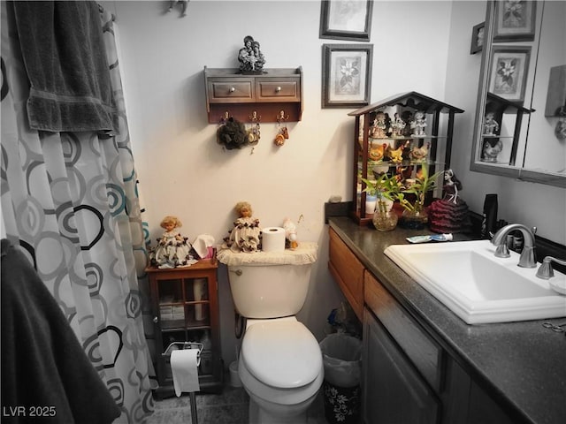 bathroom featuring toilet, curtained shower, tile patterned flooring, and vanity