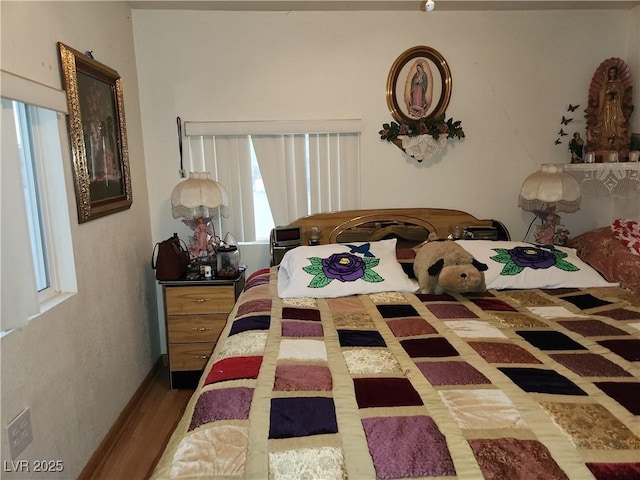 bedroom featuring multiple windows and wood finished floors