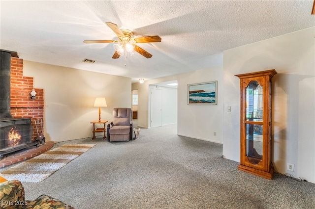 living area with carpet flooring, a ceiling fan, visible vents, and a wood stove