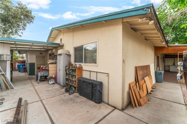 rear view of house with a patio area and stucco siding